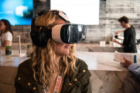 Woman wearing VR headset at counter at SXSW 2015